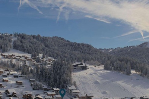 High cloud above the snow-covered mountainside and buildings in Les Gets, France – Weather to ski – Snow forecast, 28 November 2025