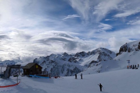 Cloudy skies above snow-covered ski slopes with skiers in Serre Chevalier, France – Weather to ski – Snow forecast, 23 January 2026
