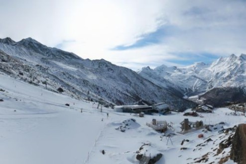 Cloudy skies over the ski slopes and snow-covered mountainside and chalet-style buildings in Saas-Grund, Switzerland – Weather to ski – Snow forecast, 23 January 2026