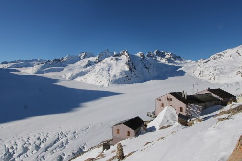 Clear blue skies over the Aletsch glacier, Switzerland, with mountains in the background and buildings in the foreground – Weather to ski – Snow forecast, 14 January 2022