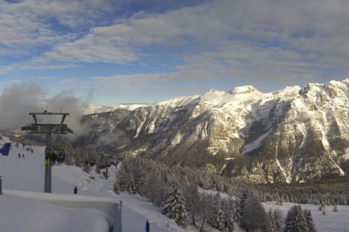Cloudy skies over the snowy mountainside in Folgarida, Italy, with chairlift and skiers in the foreground and panoramic mountain views beyond – Weather to ski – Snow report, 30 January 2026