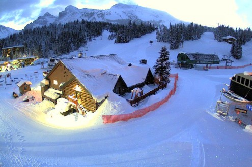 Evening view over chalet style buildings, ski slopes and the base of ski lifts in the Banff ski area – Weather to ski – Snow report, 13 January 2022