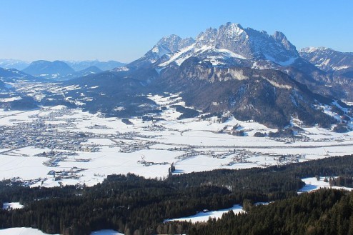 Blue skies over the mountains and valley in St Johann in Tirol, Austria – Weather to ski – Snow report, 22 January 2026