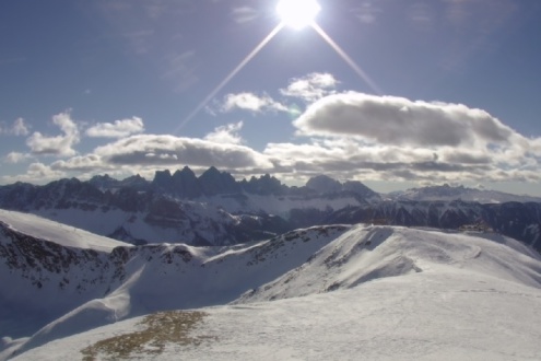 Blue skies with a few white clouds and the sun shining above snowy panoramic Dolomite mountain scenery in Brixen, Italy – Weather to ski – Snow report, 20 January 2022