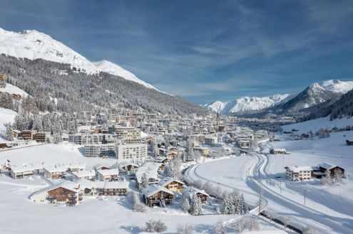 View over a very snowy Davos, Switzerland, with panoramic mountain scenery and slightly cloudy skies – Weather to ski – Half Term Snow report, 10 February 2022