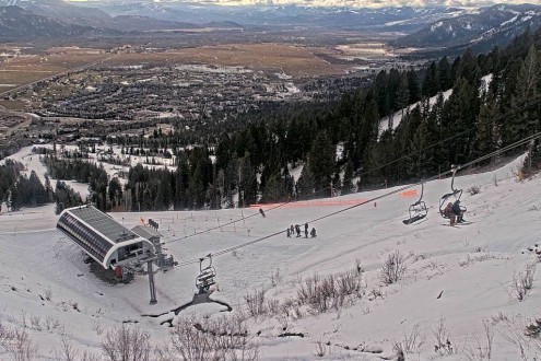 Skiers on a chairlift in Jackson Hole, Wyoming, with snow on the mountainside but very little further down the mountain – Weather to ski – Snow report, 12 December 2025