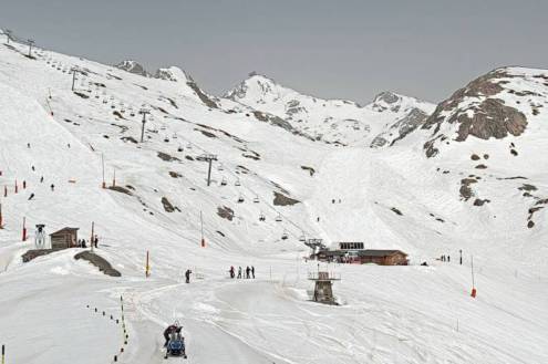 Hazy skies above snow-covered ski slopes in Alpe d’Huez, France – Weather to ski – Snow report, 18 March 2022