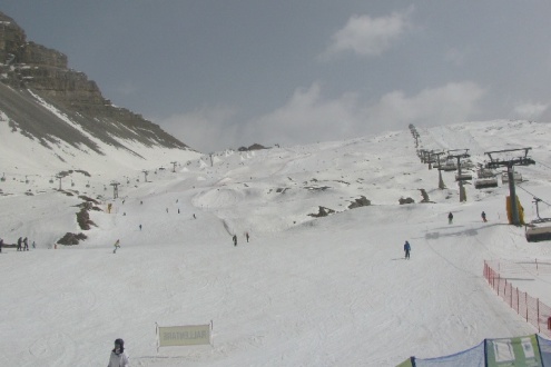 Hazy skies above snow-covered ski slopes in Madonna di Campiglio, Italy – Weather to ski – Snow report, 18 March 2022