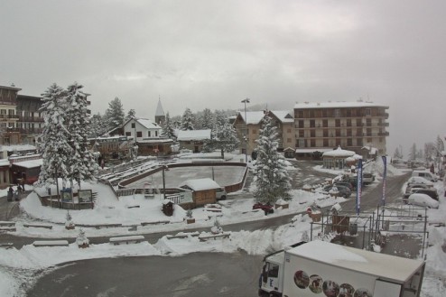 Cloudy conditions with fresh snow on the village square in Auron, France – Weather to ski – Snow report, 14 December 2022