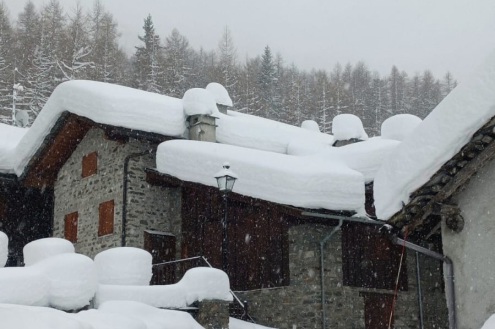 Deep snow on the roof of a traditional alpine stone building and the mountainside in Rhêmes, Italy – Weather to ski – Snow report, 19 February 2026