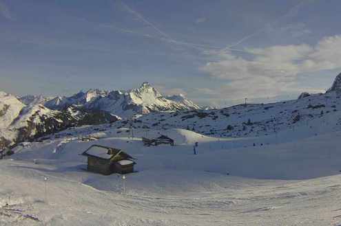 Cloudy skies and panoramic view of snow covered slopes and small chalet in Warth-am-Arlberg, Austria – Weather to ski – Snow report, 31 December 2022