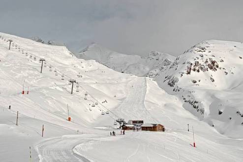 Cloudy skies over view of ski lift and skiers on the pistes in Alpe d’Huez, France – Weather to ski – Snow report, 31 December 2022