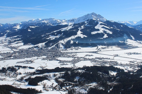 Blue skies above the snow-covered valley and mountains in St Johann in Tirol, Austria – Weather to ski – Snow report, 26 February 2026