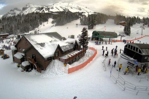 Birds eye view of base station in Banff/Lake Louise with ski lifts, skiers and snow-covered buildings – Weather to ski – Snow report, 6 January 2023