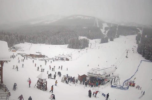 Fresh snow at the base of the Lake Louise ski area, with skiers congregating outside the ski lodge and at the base of ski lifts – Weather to ski – Snow report, 12 March 2026