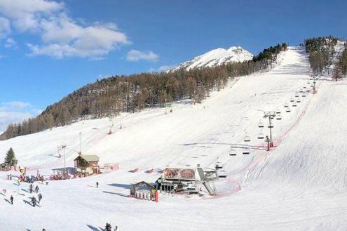 Blue skies above snow-covered ski slopes in Montgenèvre, France, with skiers and ski lifts in the foreground – Weather to ski – Snow report, 4 March 2023
