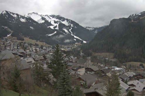 View of ski slopes in Châtel, France, with little natural snow cover lower down – Weather to ski – Snow report, 24 March 2023