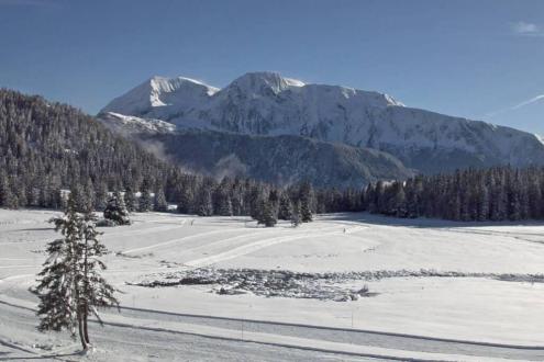 Blue skies over snow covered fields with mountain scenery beyond in Chamrousse, France – Weather to ski – Snow report, 15 December 2023