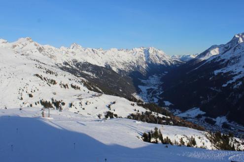 Blue skies over the snowy pistes in St Anton with view over the valley below – Weather to ski – Snow report, 30 December 2023
