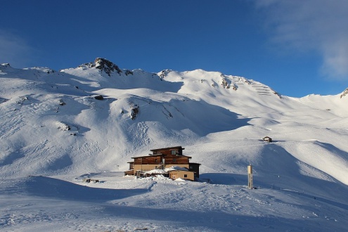 Blue skies over a mountain building set on the snowy mountainside above Heiligenblut, Austria –Weather to ski – Snow report, 12 January 2024