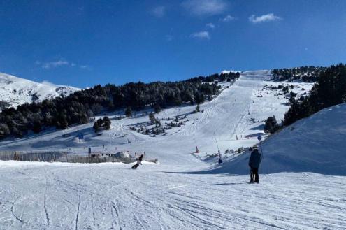 View of skiers and boarders on the snowy pistes of Granvalira, Andorra, with blue skies above – Weather to ski – Snow report, 12 January 2024
