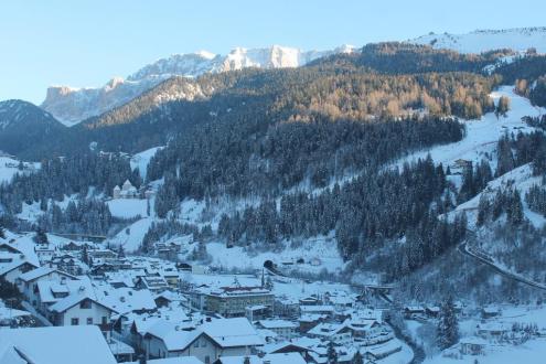 Panoramic view of village and treelined snow-covered mountainside beyond in the Val Gardena, Italy – Weather to ski – Snow report, 12 January 2024