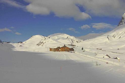 Very snowy scenes in Warth, Austria, with blue skies above and mountain building in the distance – Weather to ski – Snow report, 3 February 2024