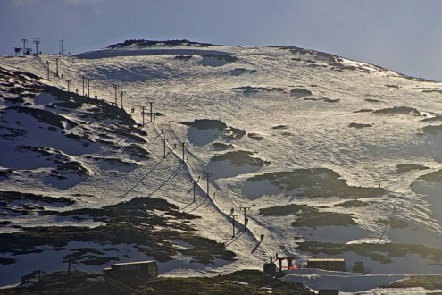 Snow-covered ski slopes and skiers on T-bar lift in Glencoe, Scotland – Weather to ski – Snow report, 25 March 2022