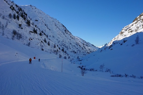 Flat section at the bottom of the Sarenne black run heading through the shade of the Gorge de Sarenne with skiers, on 21 December 2021 – Weather to ski - Our blog: Alpe d’Huez – one of the best all-round ski resorts in the Alps?
