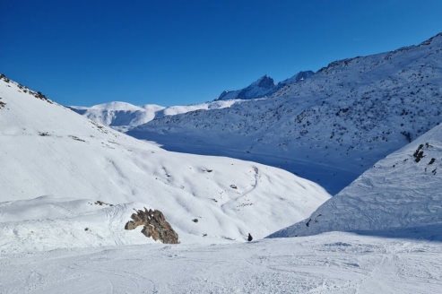 View of the Sarenne black run just before entering the Gorge de Sarenne with sunny skies and skier in the distance, on 21 December 2021 – Weather to ski - Our blog: Alpe d’Huez – one of the best all-round ski resorts in the Alps?