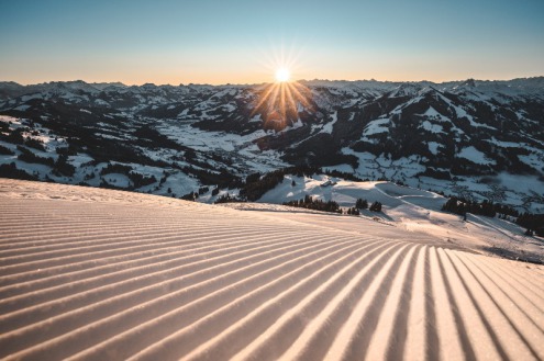 Sunrise over a perfectly groomed ridged piste with views down to the valley in the SkiWelt, Austria - Weather to ski – Today in the Alps, 27 January 2022