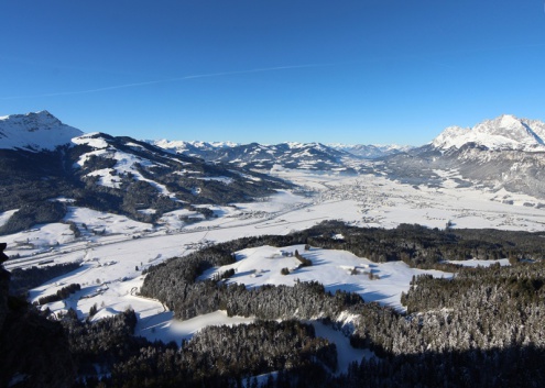 Panoramic snowy mountain view over St Johann in Tirol, Austria, with blue skies above  – Weather to ski – Today in the Alps, 9 February 2022