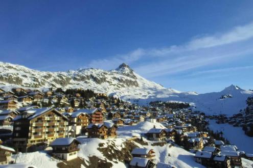 View across the village of Bettmeralp in the Aletsch Arena, Switzerland, with chalet-style buildings and snow-covered slopes and mountains beyond under mainly blue skies with a little high cloud  – Weather to ski – Today in the Alps, 2 March 2022