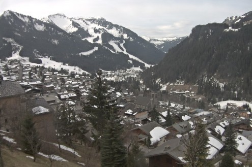 View over chalet-style buildings in the ski resort of Châtel in France, towards the ski area in the distance – Weather to ski – Today in the Alps, 11 March 2022