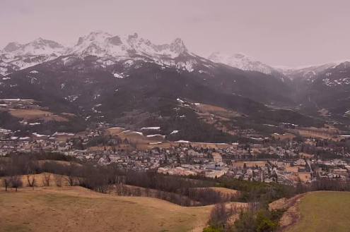 Panoramic mountain view with mist with an orange sandy hue in La Condamine-Châtelard, France – Weather to ski – Today in the Alps, 18 March 2022
