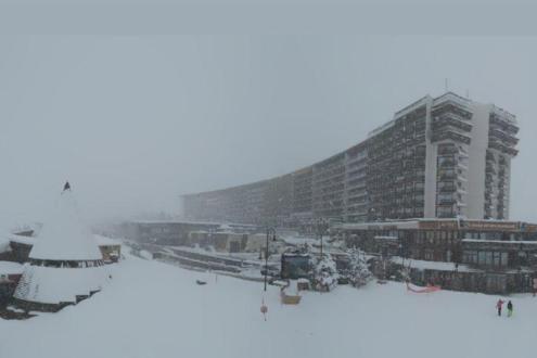 Heavy snow and cloud in the centre of the ski resort of Tignes, France, with snow-covered buildings – Weather to ski – Today in the Alps, 8 April 2022