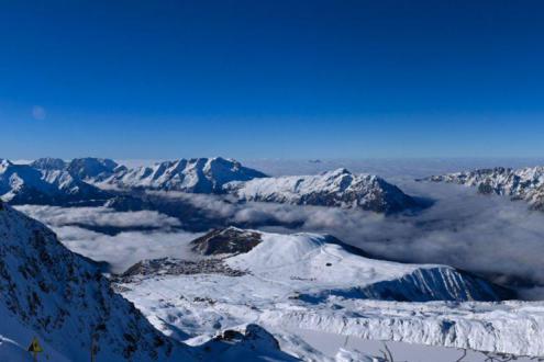 Blue skies over snow covered mountain scenery in Alpe d’Huez, France, with cloud over the valley – Weather to ski – Today in the Alps, 30 November 2022