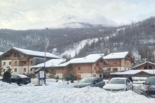 Snow-covered chalet style buildings in the village of Chantemerle in Serre Chevalier, France, with view towards the ski slopes beyond – Weather to ski – Today in the Alps, 3 January 2023
