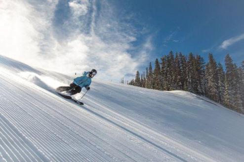 Blue skies over the pistes in Vail, Colorado, with skier in the foreground – Weather to ski – Snow report, 8 December 2023