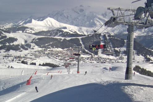 Bright weather and plenty of snow on the slopes in Les Saisies, France, with view over the valley, and ski lift with skiers in the foreground – Weather to ski – Today in the Alps, 10 December 2023