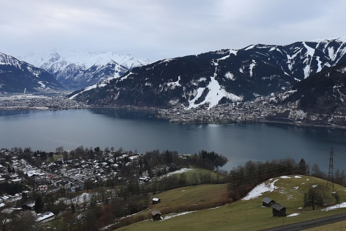 View across the lake towards the snow-covered slopes of Zell am See – Weather to ski – Today in the Alps, 24 December 2023