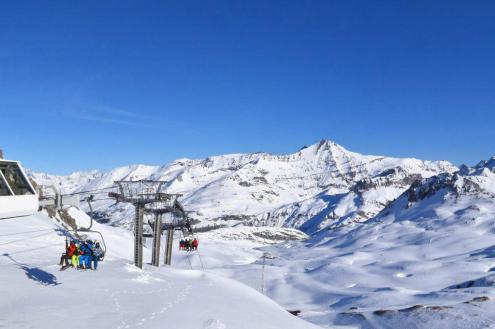 Blue skies over the snow-covered pistes of Val d’Isère, France, with view of skiers and chairlift – Weather to ski – Today in the Alps, 28 January 2024