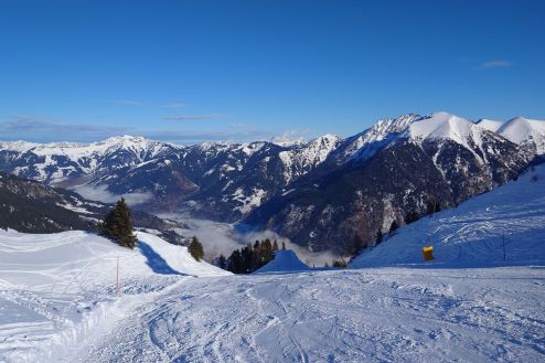 View of the cloud filled valley in Bad Gastein, Austria, with blue skies above from the top section of the wonderful Hohe Scharte piste - Weather to ski - Our blog: Bad Gastein - 5 reasons to visit this forgotten gem