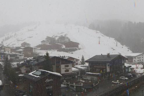 Rain starting to turn to snow over the buildings and ski slopes in Lech, Austria – Weather to ski – Today in the Alps, 23 March 2024