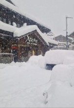 Deep snow covering the ground and tables in Verbier, Switzerland with snow falling and snow-covered chalet-style buildings on 17 April 2025 – Our blog: Massive snowfalls in the Alps during this week’s historic April storm!