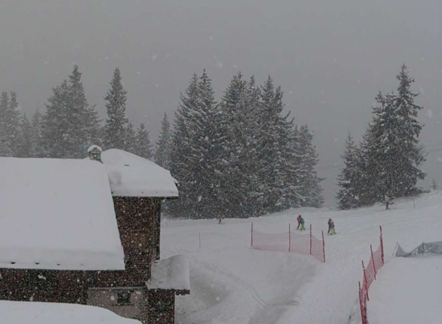 Heavy snow falling over the snow-topped buildings and trees on the mountainside in La Rosière, France – Click to view Weather to Ski's latest weather & snow forecast for 8 January 2026