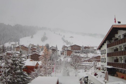 Snow-covered ski slopes and village buildings in Lech ski resort, Austria – Today in the Alps, 21 November 2025
