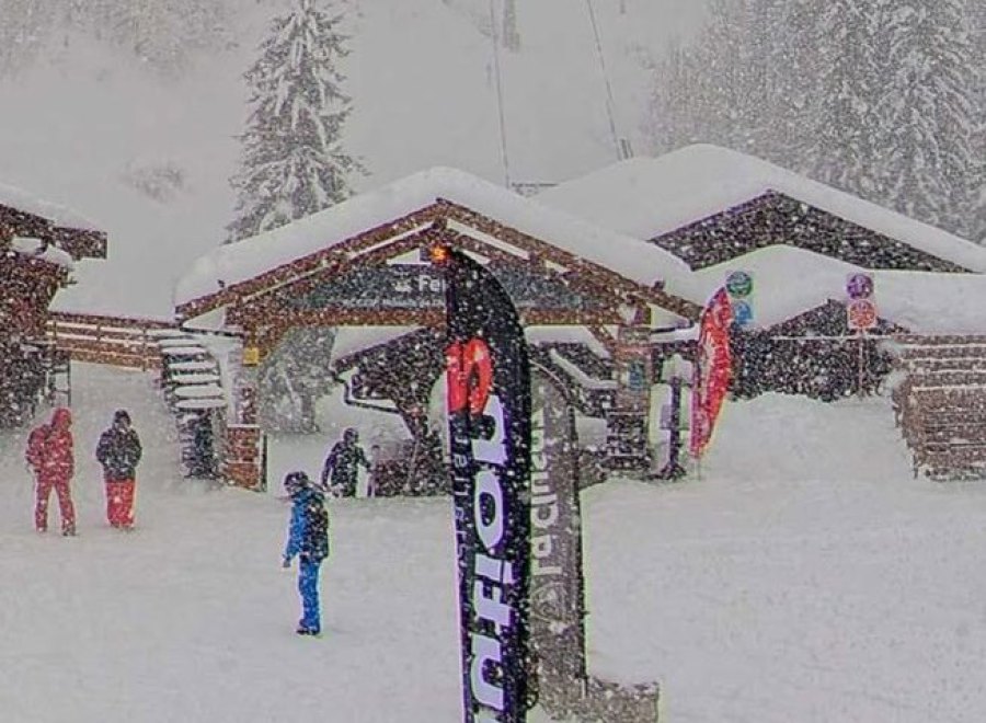 Snow falling over the ski slopes, skiers and chalet-style building in La Clusaz ski resort in France – Link to Weather to ski's full Snow report, 30 January 2026