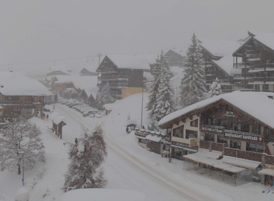 Heavy snow falling on the already deep snow-covered streets and chalet-style buildings in Les Saisies, France – Link to Weather to ski's full Snow report, 19 February 2026