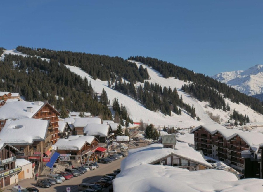 Blue skies over the snow-topped buildings in Les Saisies, with ski slopes beyond – Link to Weather to ski's full Snow report, 26 February 2026